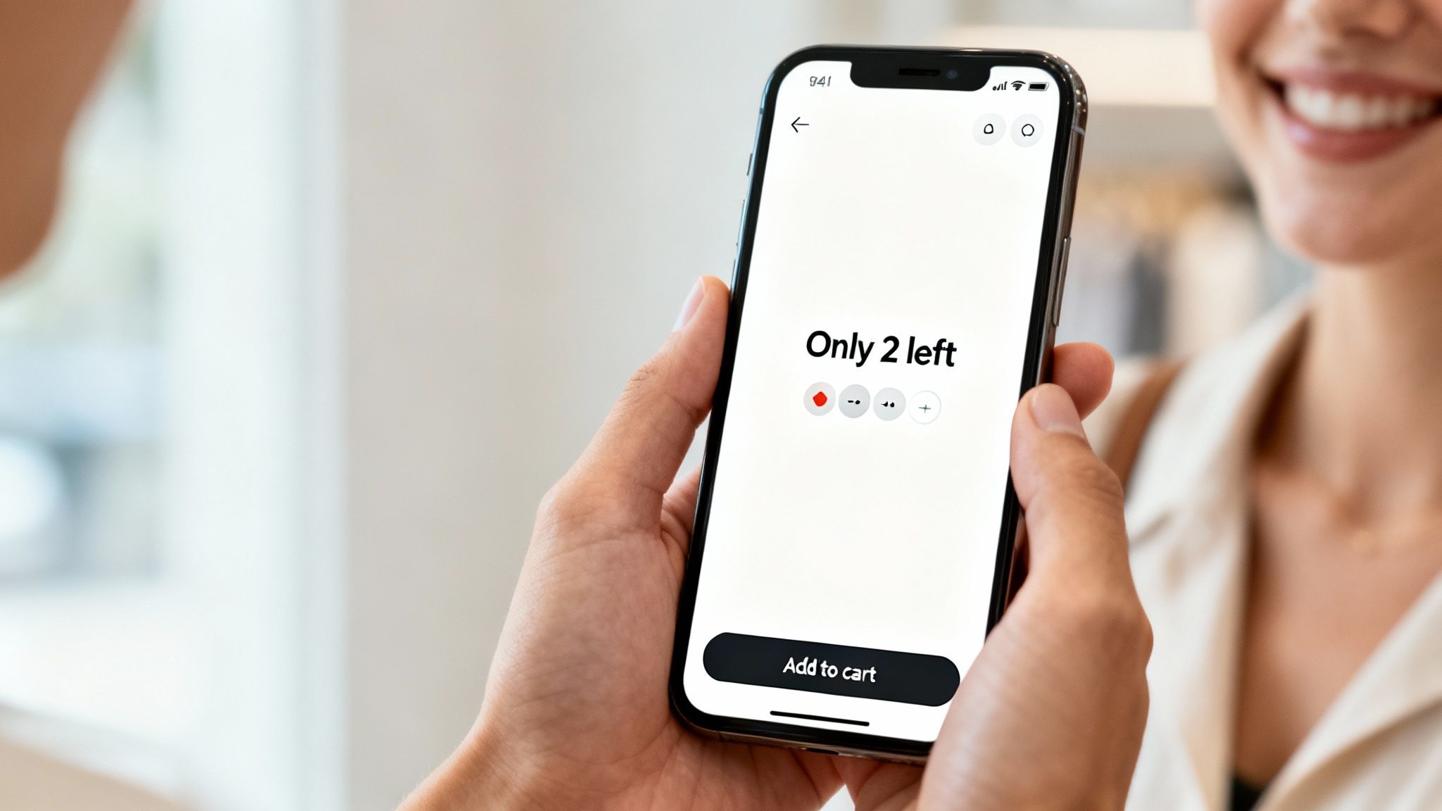 Close-up of a hand holding a smartphone displaying an online shopping page with product scarcity notification.